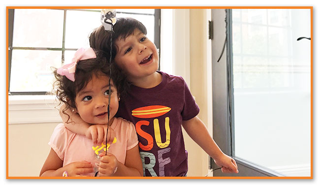 Kids sitting in grass - Montclair Pediatric Dental Near Verona